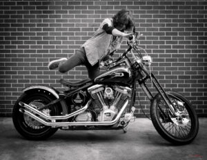 Kelly Hansen of Foreigner getting on custom Harley Davidson motorcycle