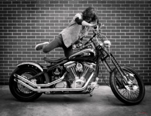 Kelly Hansen of Foreigner getting on custom Harley Davidson motorcycle