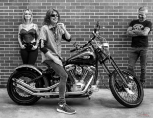 Kelly Hansen of Foreigner on custom Harley Davidson motorcycle with people in black and white