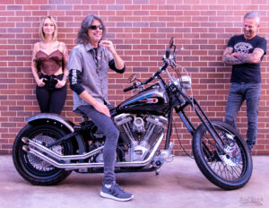 Kelly Hansen of Foreigner on custom Harley Davidson motorcycle with people