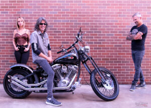 Happy Kelly Hansen of Foreigner on custom Harley Davidson motorcycle with people