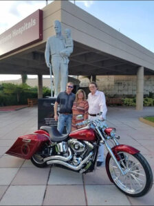 Shawn Barker with others at Foreigner Shriners Childrens' at hospital with motorcycle